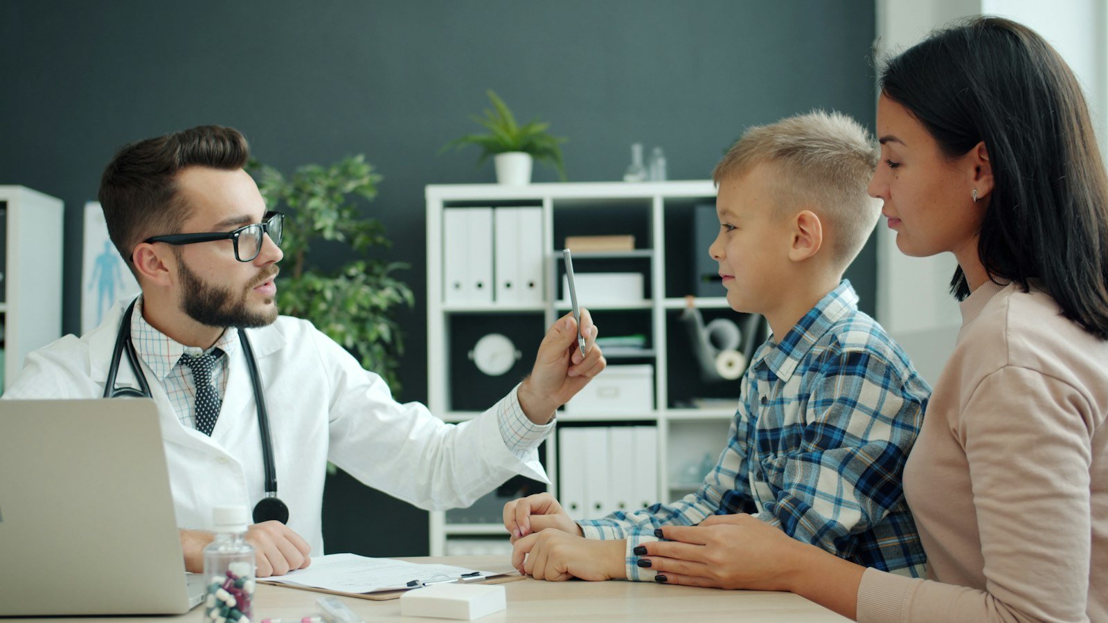 A doctor examining a child with the mother present